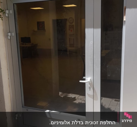 דלת זכוכית עם מסגרת מתכתית אפורה